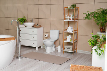 Interior of bathroom with toilet bowl, sink and shelf unit