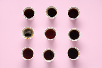 Composition with takeaway paper cups of tasty coffee on pink background