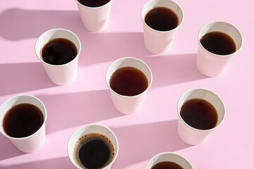 Composition with takeaway paper cups of tasty coffee on pink background, closeup