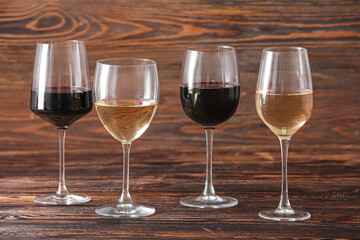 Glasses of different exquisite wine on wooden background