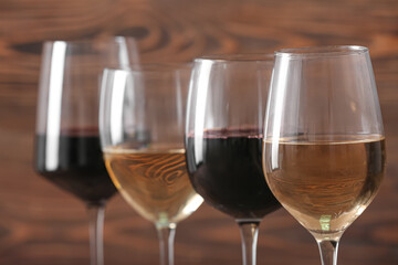 Fototapeta premium Glasses of different exquisite wine on color background, closeup