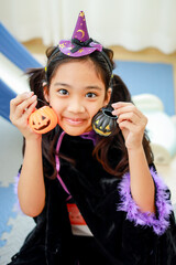 Halloween, holiday and childhood concept. Little kids southeast asian on halloween dressed in a witch costume.