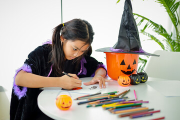 Halloween, holiday and childhood concept. Little kids southeast asian on halloween dressed in a witch costume.