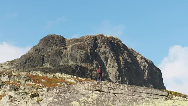 Male climber in front of Jotunheimen Bitihorn mountain in Norway; drone reveal