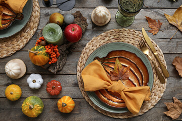Autumn table serving with pumpkins and dry leaves on grey wooden table