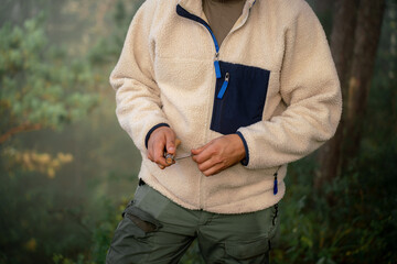 Close-up of young traveler male tourist with knife in forest