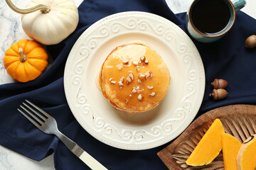 Plate of tasty pumpkin pancakes with nuts and honey on white background