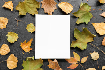 Naklejka na ściany i meble Autumn leaves with blank card on black grunge background