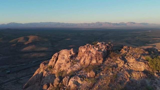A beautiful, cinematic 4k aerial landscape video shot during sunset. Gorgeous reveal of mountains and the i10 highway. See the semi-trucks traveling along in golden hour.