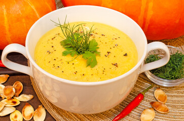 Pumpkin hot puree soup on a wooden table