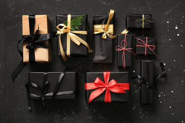 Many Christmas gift boxes with coniferous branch on black background