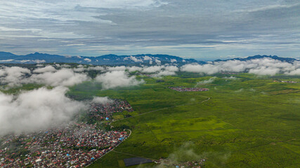 Top view of valley with tea plantations and farmland with clouds. Kayu Aro, Sumatra, Indonesia. Tea estate landscape.