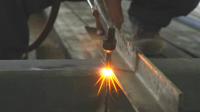 Gas welder cutting a steel in factory