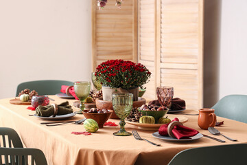 Beautiful autumn table setting with bouquet of flowers, pumpkins and pine cones
