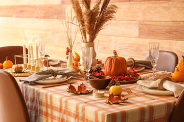 Autumn table setting with pumpkins, dry leaves and pampas grass