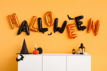 Word HALLOWEEN made of balloons on yellow wall in living room