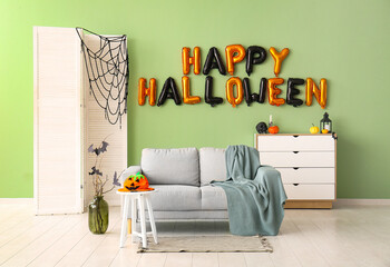 Interior of living room decorated for Halloween with balloons and sofa