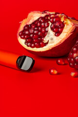 Electronic cigarette with pomegranate flavor on red background