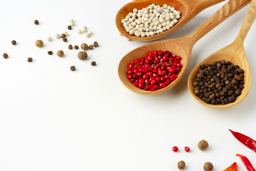 Wooden spoons with various spices isolated on white background
