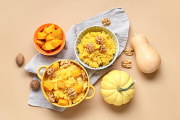 Pot and bowl of tasty millet porridge with pumpkin on orange background