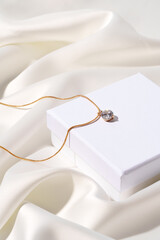 Golden chain in jewel box on silk background