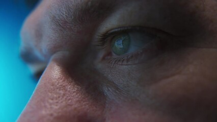 Close up shot of man eye surfing internet at night 