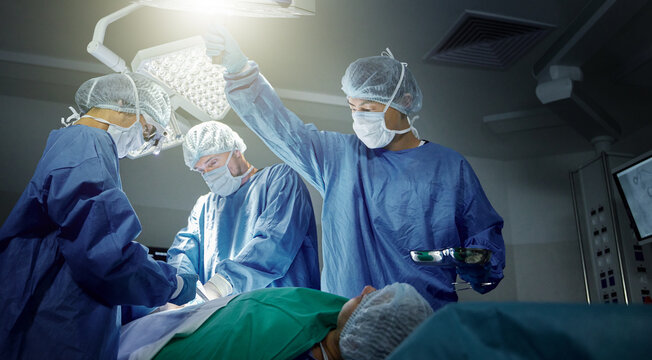 Teamwork, healthcare and surgeons working on a surgery for medical treatment in a theatre room. Collaboration, career and professional doctors doing an operation on a patient in a hospital or clinic.