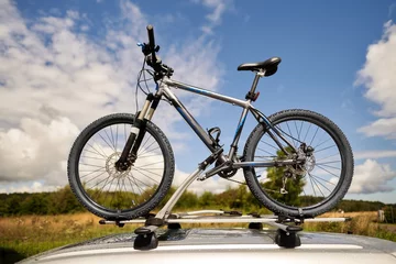Tuinposter Top roof bicycle mount. Concept of transporting bikes and luggage on the top of the car. © AlexGo