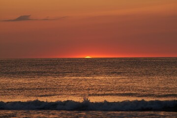Fototapeta na wymiar Radiant Sunset Over the Ocean. The Glowing Sun Sinking on the Horizon