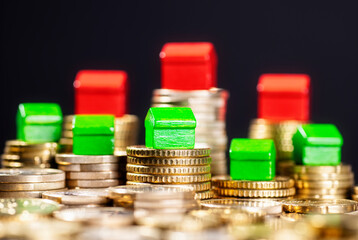 Falling real estate prices. Green houses on low and red on high coin stacks.