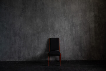 One black vintage chair in the interior of an empty dark room