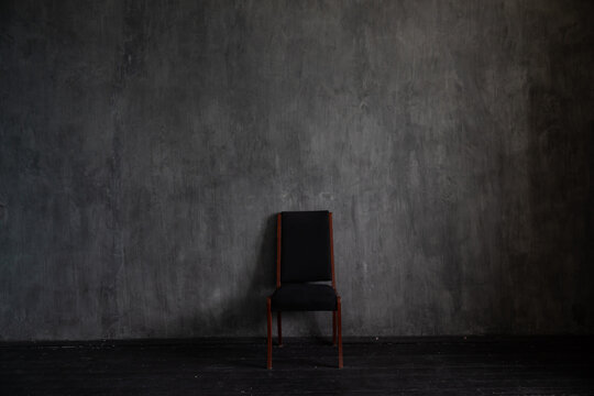 One black vintage chair in the interior of an empty dark room