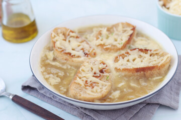 A ceramic bowl with French onion soup	