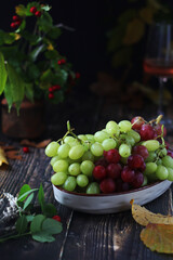 A bowl with red and green grape in rustic style