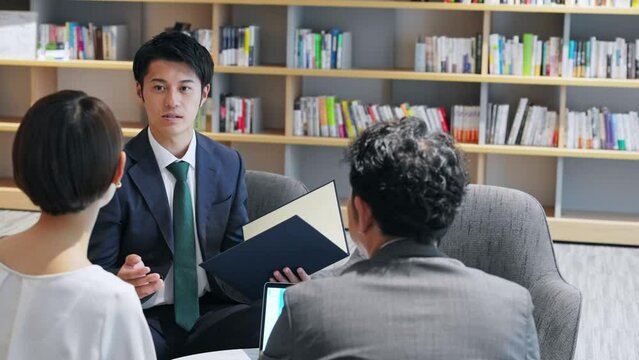 ロビーで会話するミドルカップルと相談員