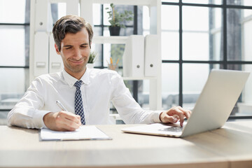 Fototapeta na wymiar young businessman in a white shirt and tie working in a modern office.