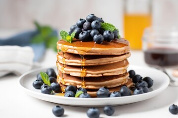 stack of vegan pancakes with maple syrup and blueberries