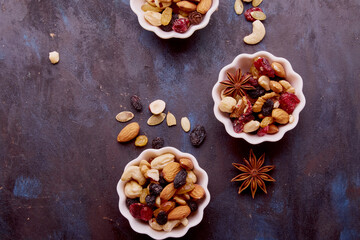 Aesthetic saucers with mixed nuts close up. Walnuts, almonds, hazelnuts, cashew, raisins and cranberries. Healthy food and snacks.