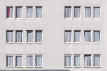 pattern of a white house wall with windows in geometrical order as symbol for apartment building