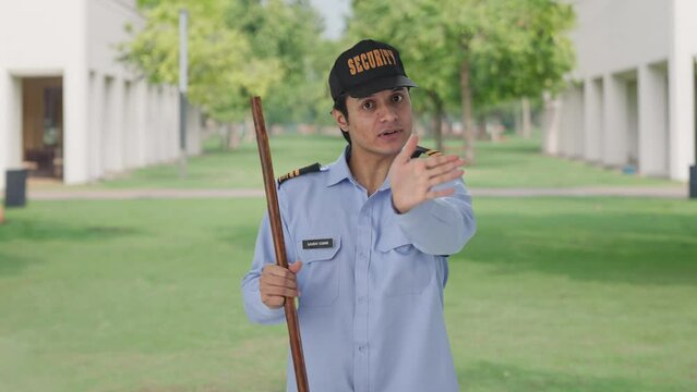Happy Indian security guard telling directions to someone