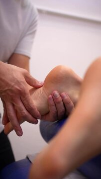 Physiotherapeutic massage to an unrecognizable woman lying on a stretcher on the foot