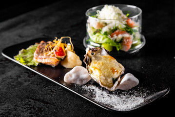 salad with shrimp, Fried fillet dorado fish and Oysters in a plate 