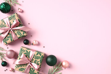 Overhead view Christmas decorations, gift boxes, fir tree branches, confetti on pastel pink...