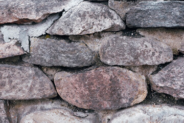 Retaining wall made of large large natural stones. Stacked stones at the base of the building. Close-up