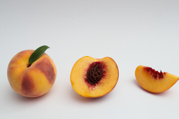 Whole and cut ripe peach on white background. Ripe pinky-yellow peaches.