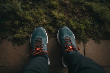 Top view of running shoes standing on stone path or roadside.