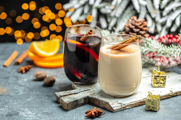 glasses of mulled wine and eggnog, Christmas winter alcohol drinks decorated by christmas lights