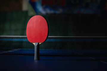 table tennis racket On the blue ping pong table - obrazy, fototapety, plakaty