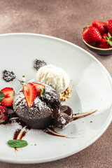 Chocolate fondant lava cake with strawberries, traditional french chocolate cake with liquid filling