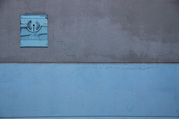 Deteriorated and discolored wifi sign or signal due to sun and inclement weather on a wall